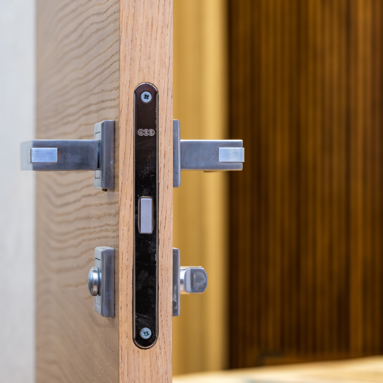 Einsteckschloss Detailansicht eines Türschlosses aus Metall in einem Holzrahmen.